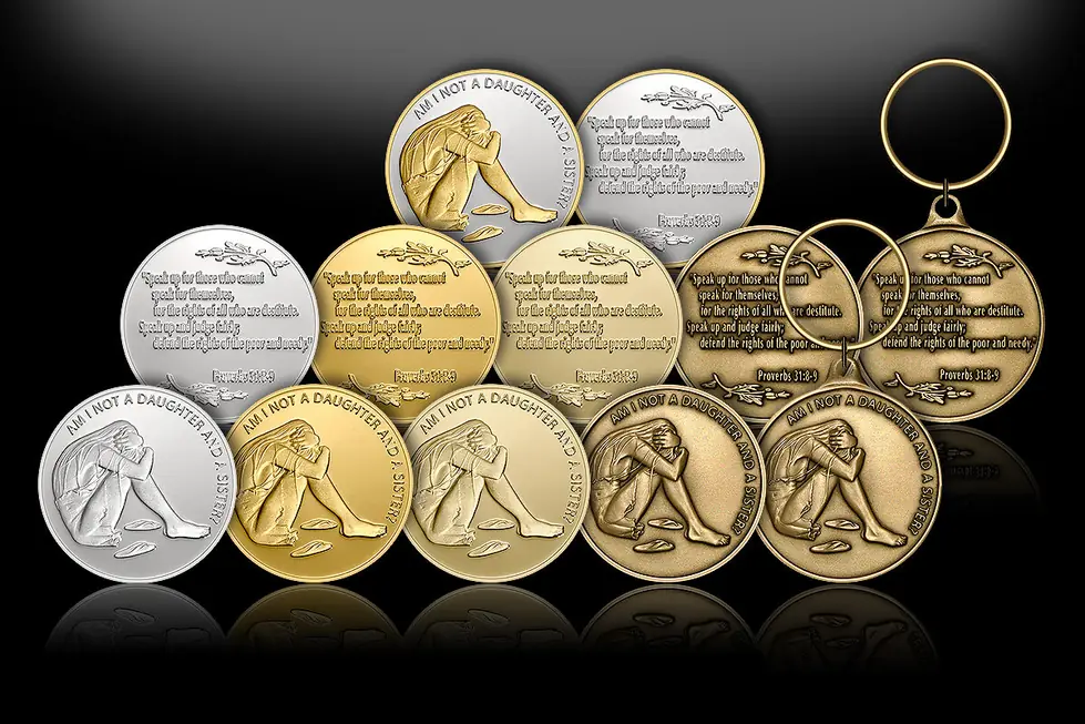 Gold, silver and bronze King Tribe medallions and keychains on black
